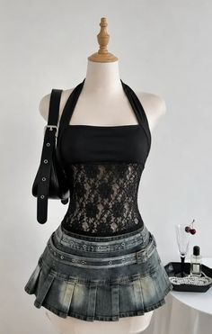 Mannequin wearing a black lace halter top and a denim pleated skirt