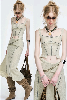 Woman with blonde hair in a crop top and long skirt with boots and sunglasses