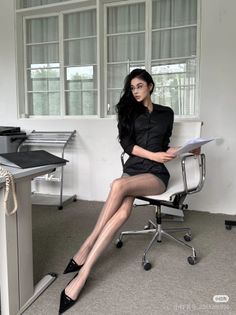 Woman in a black shirt and sheer stockings sitting in an office chair