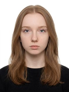 Young woman with long red hair and blue eyes wearing a black sweater