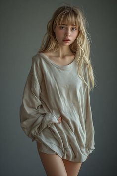 Woman with blonde hair wearing an oversized shirt, revealing her legs