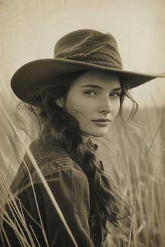 Woman in a cowboy hat in a field of tall grass, sepia tone