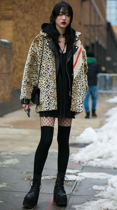 Person in a leopard print coat and fishnet stockings on a snowy street