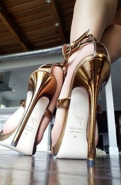 Person wearing gold high heels with exposed skin from a low angle