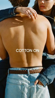 Man's bare back with a woman's arm around him, both wearing denim