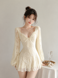 Woman in a cream lace dress with long sleeves and an updo