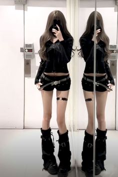 Person in black outfit with platform boots taking a mirror selfie