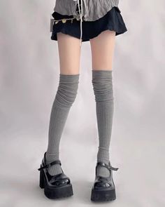 Person wearing a mini skirt, thigh high socks, and platform mary jane shoes