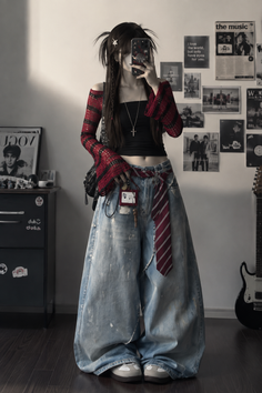 Person in a cropped top and wide leg jeans taking a mirror selfie