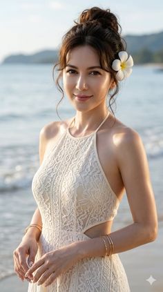 Woman in a lace dress with a frangipani flower in her hair on a beach