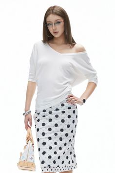 Woman in a white off-shoulder top and polka dot skirt with glasses