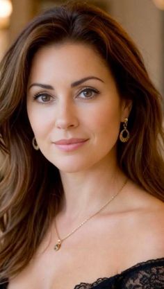 Woman with long brown hair and jewelry looking directly at the viewer