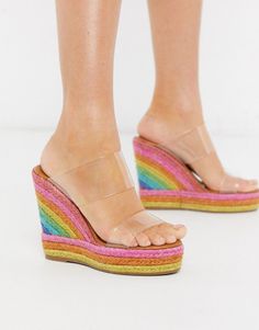 Pair of rainbow espadrille wedge sandals with clear straps on a white background