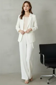 Woman in a white suit standing in an indoor setting