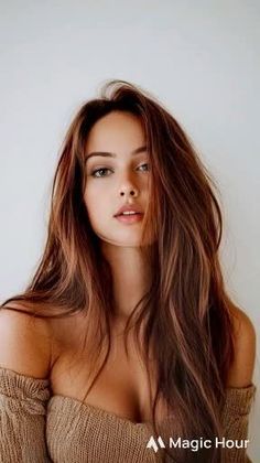 Woman with long brown hair wearing an off-shoulder top, looking at the camera