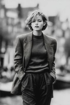 Woman with short hair wearing a blazer and turtleneck outdoors