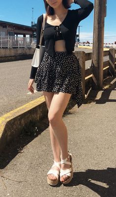Woman in a polka dot skirt and crop top outdoors on a sunny day