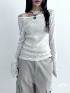 Person with long black hair wearing an off-shoulder sheer top and cargo pants