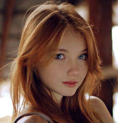 Young woman with red hair and blue eyes looking at the camera