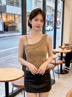 Woman in a brown top and black skirt standing in a cafe
