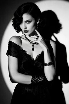 Woman in a black dress and jewelry with dramatic lighting and shadow