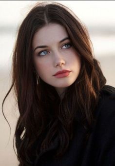 Woman with long dark hair and blue eyes wearing red lipstick