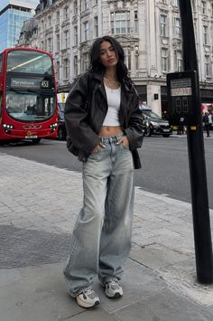 Woman in a leather jacket and baggy jeans on a city street