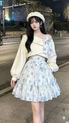 Woman with long black hair wearing a beret and floral dress at night