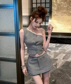 Woman in a sparkling gray one-shoulder top and mini skirt