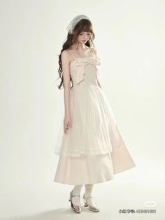 Woman in a light-colored dress with a bow detail and lace headscarf