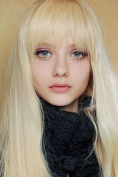 Close-up portrait of a young woman with long blonde hair and bangs