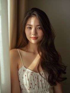 Woman with long hair in a floral dress, illuminated by natural light indoors
