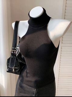 Black ribbed turtleneck top on a mannequin with a black shoulder bag
