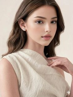 Woman with long hair and earrings in a light-colored top