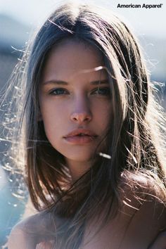 Woman with long hair in backlight, looking directly at the viewer