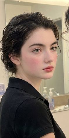 Woman with short dark hair and a black shirt looking to the side