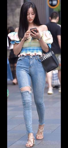 Woman in an off-shoulder top and ripped jeans on a street