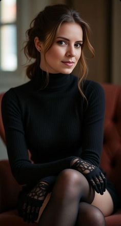Woman in a black turtleneck, lace gloves, and stockings sitting indoors