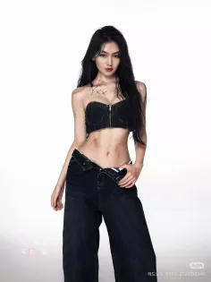 Woman with long black hair wearing a denim top and unbuttoned jeans