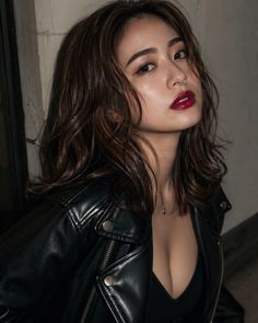 Woman with red lipstick and a leather jacket, showing cleavage