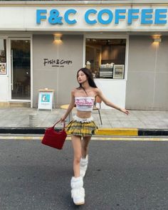 Woman in a plaid skirt and crop top walking on a street