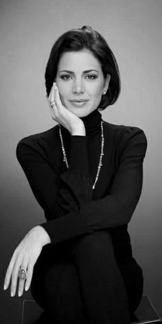 Woman with short hair wearing a turtleneck and jewelry in a black and white portrait