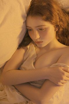 Woman with long red hair lying down with exposed skin and cleavage