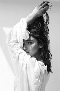 Woman in a white shirt with wet long hair in a dramatic black and white portrait
