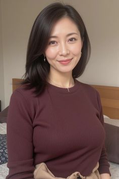 Woman with dark hair wearing a ribbed top and jewelry indoors