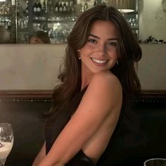 Woman with long dark hair smiling in a restaurant
