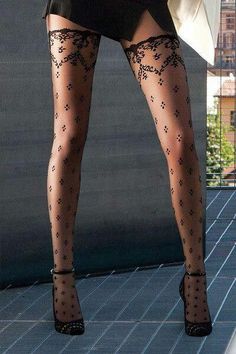 Woman's legs in patterned stockings and high heels outdoors
