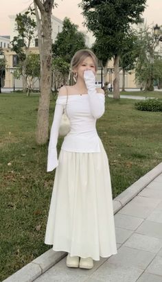 Woman in a white off-shoulder top and long skirt outdoors