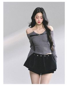Woman with long black hair wearing an off-shoulder top and black shorts