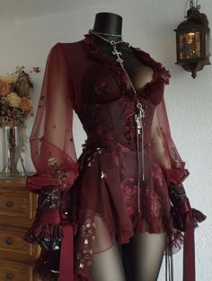 Gothic-style red dress with sheer fabric and a corset on a mannequin